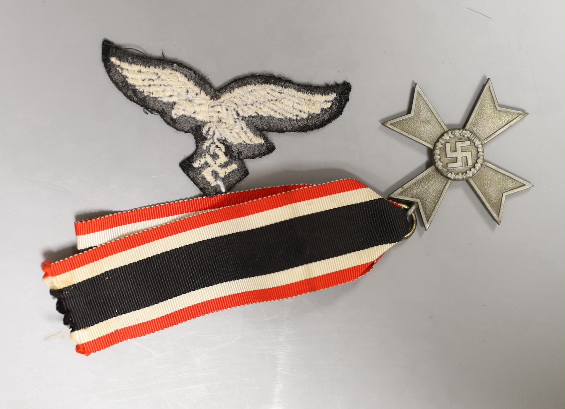 A German WWII War Merit Cross medal and a third reich badge